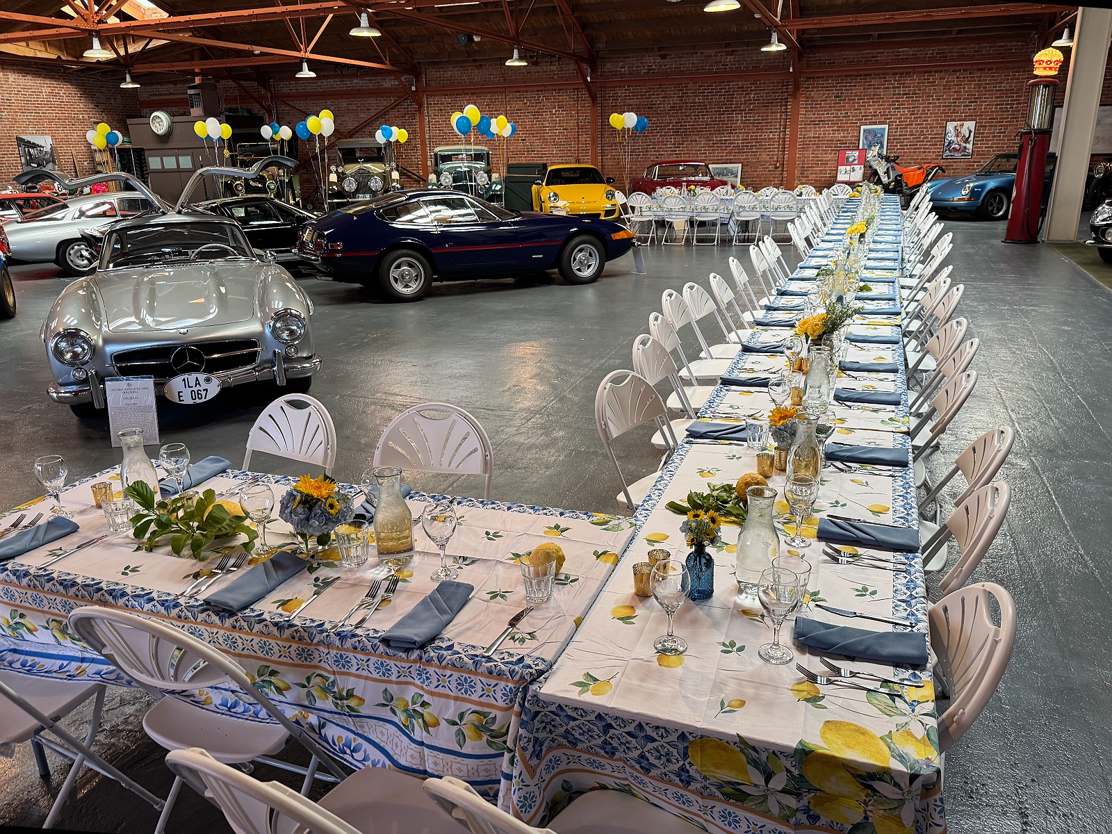One long table set with lemon-print linens beside a Gullwing