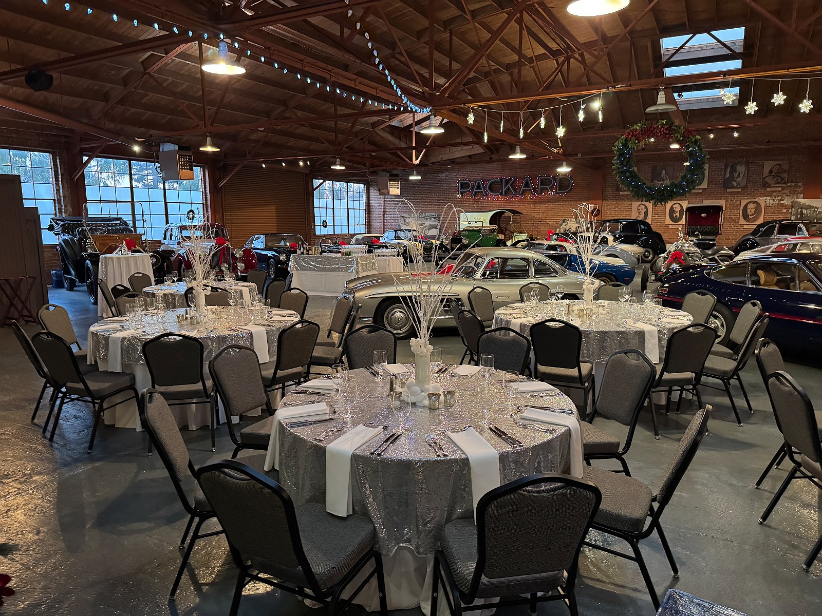 Silver and white holiday tables beneath the Packard sign