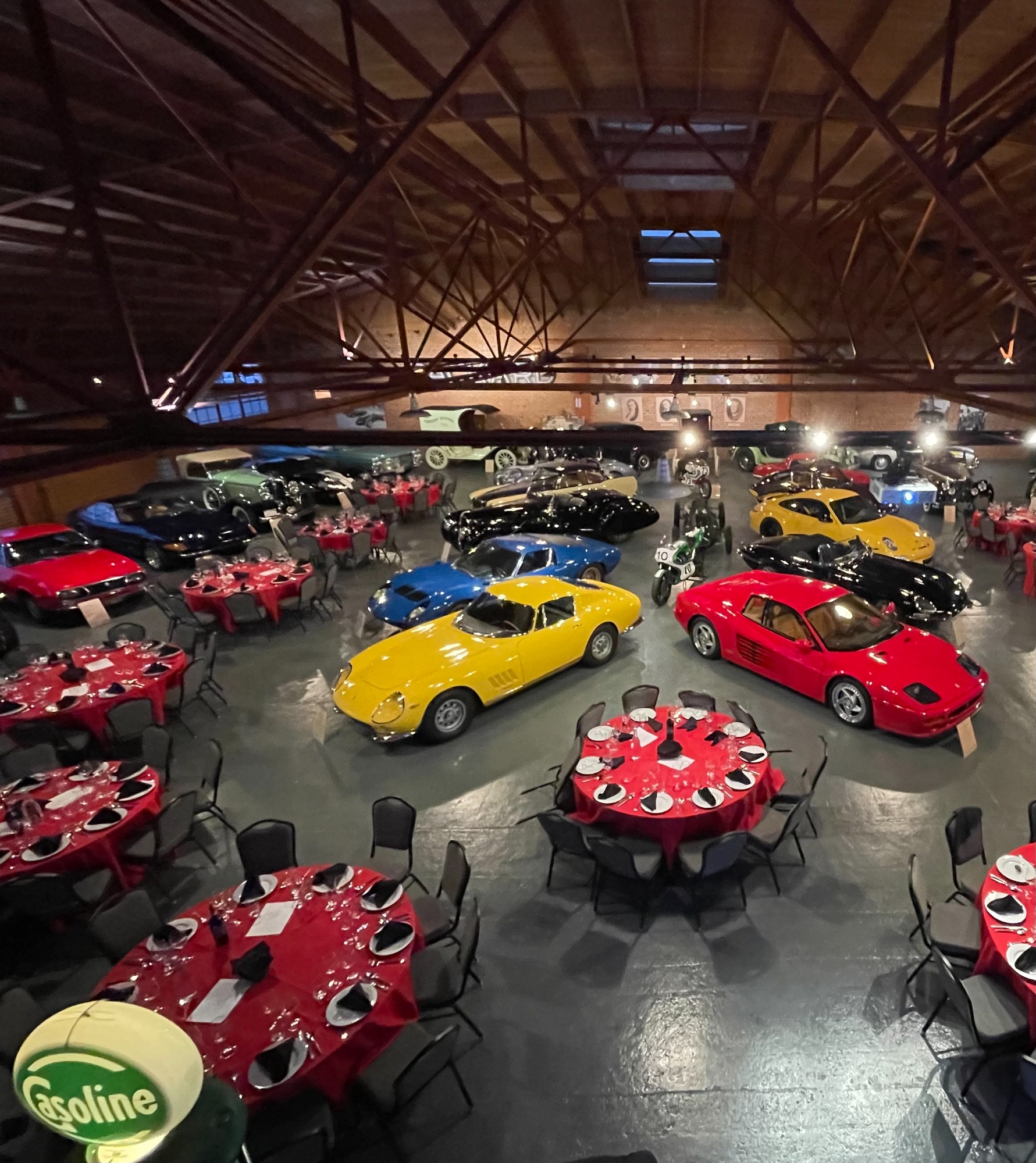 The Candy Store hall set for a banquet, tables among great cars
